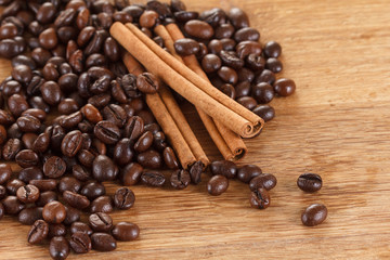 Coffee beans with cinnamon and anise on wooden table