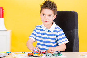 kleiner junge spielt mit autos