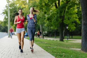 Fotobehang Twee vrouwen joggen in park © NDABCREATIVITY