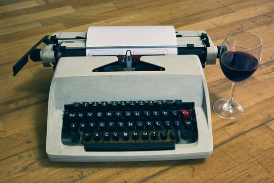 Typewriter with Glass of Wine on Wooden Floor