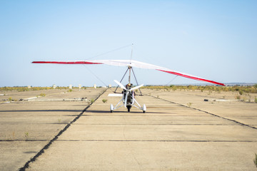 Hang-gliding, standing at dawn on the runway