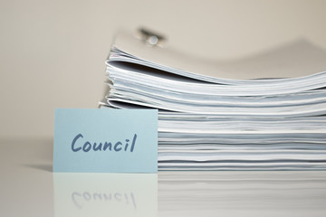 Council; Stack of Documents on white desk and Background.