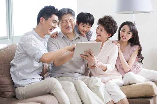 A happy family using digital tablet at home