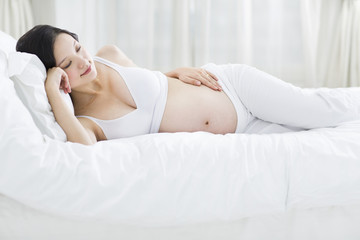 Obraz na płótnie Canvas Pregnant woman lying in bed