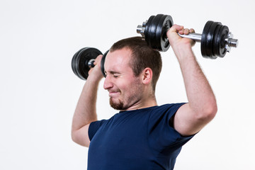Fototapeta na wymiar Close up of young man lifting weights over grey background
