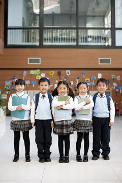 Portrait of smiling students standing in a row at school