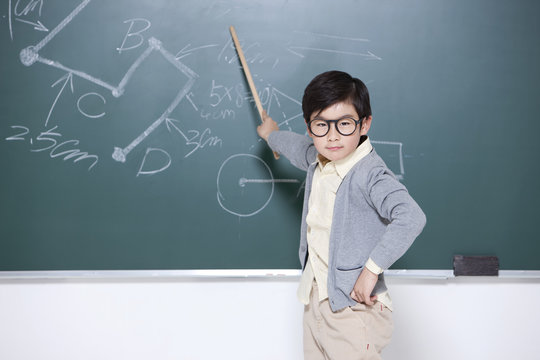 Active Little Boy Playing Teacher In Classroom