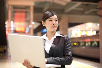 Young businesswoman using her laptop at the train station