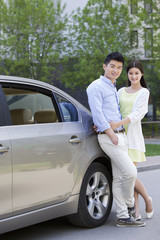 Happy young couple and car