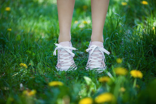 Female legs in shoes on the grass