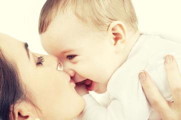 happy mother kissing baby boy