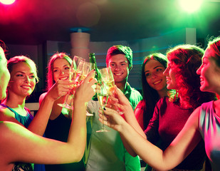 smiling friends with wine glasses and beer in club