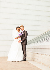 Naklejka premium bride and groom on the background of modern architecture