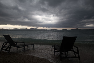 Fototapeta na wymiar Two chaise lounges on beach