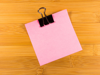 Sticky note on wooden background, empty space for text
