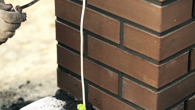 Male hands build fence in homestead
