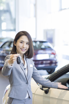 Saleswoman showing car key