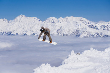 Flying snowboarder on mountains. Extreme sport.