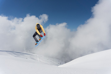 Flying snowboarder on mountains. Extreme sport.