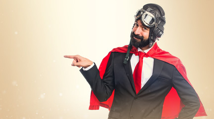 Super hero businessman pointing to the lateral