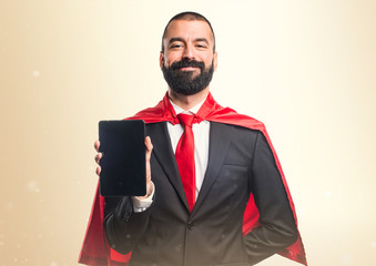 Super hero businessman holding a tablet