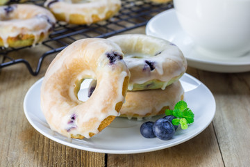 Freshly baked baked doughnuts with blueberries and lemon glaze, for breakfast