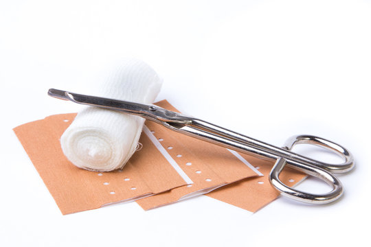 Pflaster mit Schere und Mullbinde