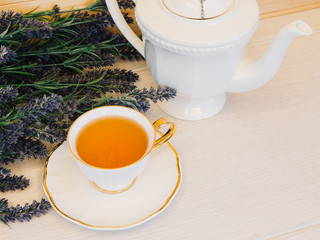 Cup of tea with flower on a wooden background top view