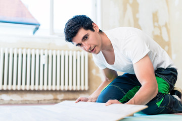 Handwerker legt den Boden in einer Wohnung