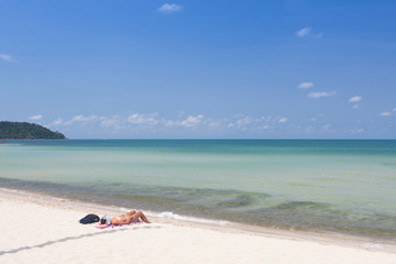 Fototapeta na wymiar Tourists relaxing in the white beach