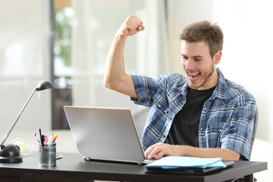 Euphoric Winner Man Using A Laptop At Home