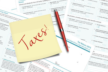 taxes note, pen and uk tax forms lying on  desk