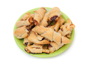 A green plate of cookies with jam, isolated on white background