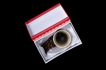 a cup of coffee in a gift box on a black background