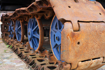 The old rusty caterpillar of the crawler tractor