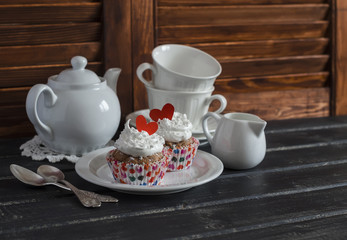 Valentine's day romantic Breakfast. Banana oat cupcakes and a tea set on a dark wooden table