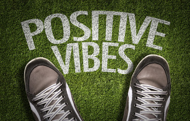 Top View of Sneakers on the grass with the text: Positive Vibes