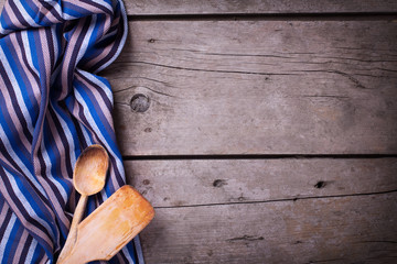 Kitchen towel and kitchen tools on vintage  wooden background.