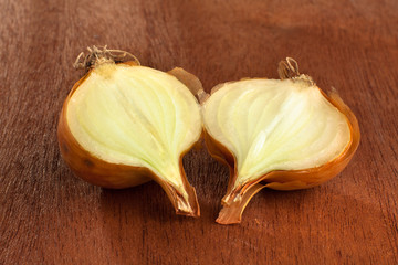 halves of onion on wooden background