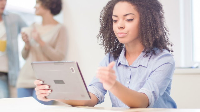 Female employee is using portable tablet. 