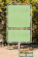 Zwei unbeschriftete grüne Schilder an einem Metallpfahl