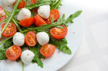 Fresh salad of arugula, cherry tomatoes and mozzarella