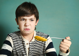 preteen handsome boy with tablespoon of pumpkin soup