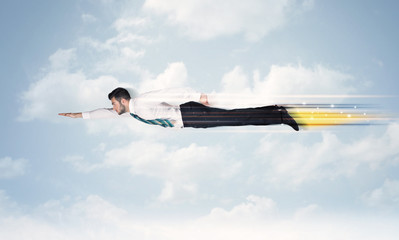 Happy business man flying fast on the sky between clouds