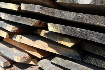 Ends of the rough pine boards in the outdoor stack