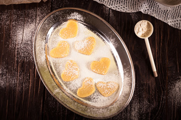 cookies in  shape  heart metal plate with flour on a wooden  bac