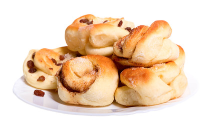 Golden ruddy buns with raisin on a white plate.