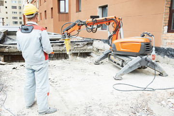 builder worker operating demolition machine