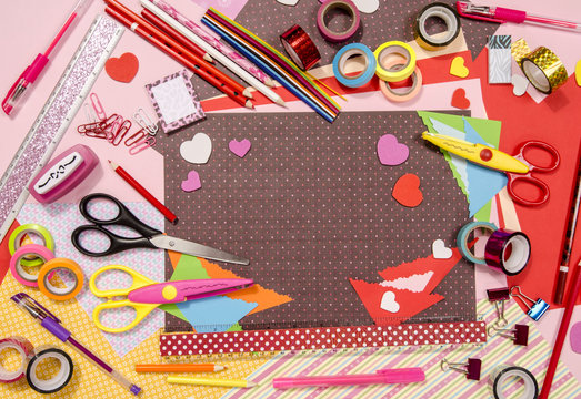 Arts and craft supplies for Saint Valentine's. Color paper, pencils, different washi tapes, craft scissors, hearts supplies for decoration.