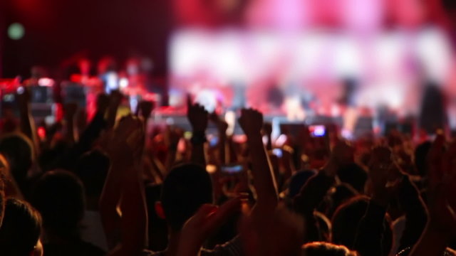 Crowd of people raising hands up at rock concert
